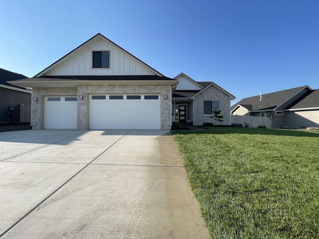 715 W Basalt Ridge Dr, Spokane, WA 99224 - view of front of house with board and batten siding, stone siding, a front lawn, driveway, and an attached garage