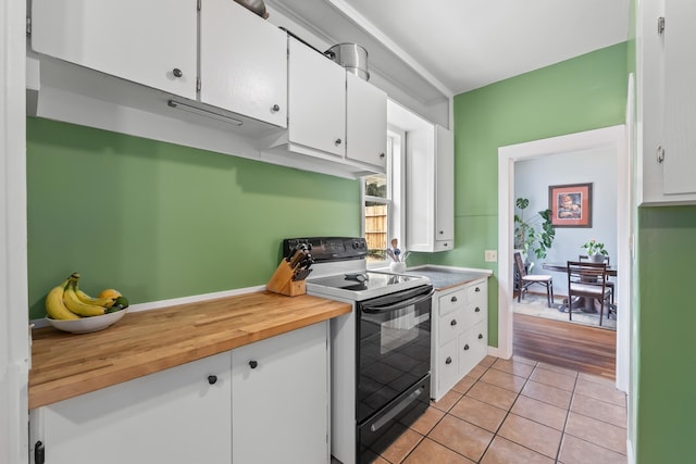 697 N Hofstetter St, Colville, WA 99114 - kitchen with black range with electric cooktop, white cabinetry, wood counters, and light tile patterned floors