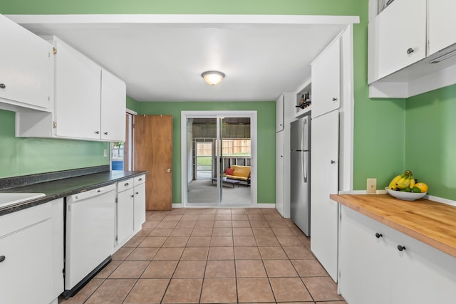 697 N Hofstetter St, Colville, WA 99114 - kitchen featuring white dishwasher, white cabinets, freestanding refrigerator, light tile patterned flooring, and baseboards