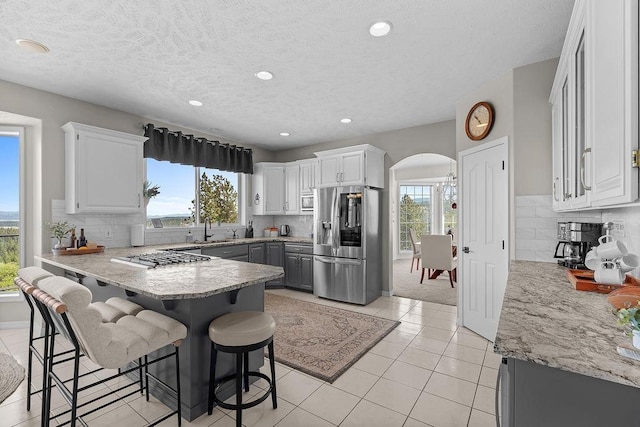 10409 E Grouse Mountain Ln, Spokane, WA 99206 - kitchen featuring stainless steel appliances, a sink, arched walkways, plenty of natural light, and recessed lighting