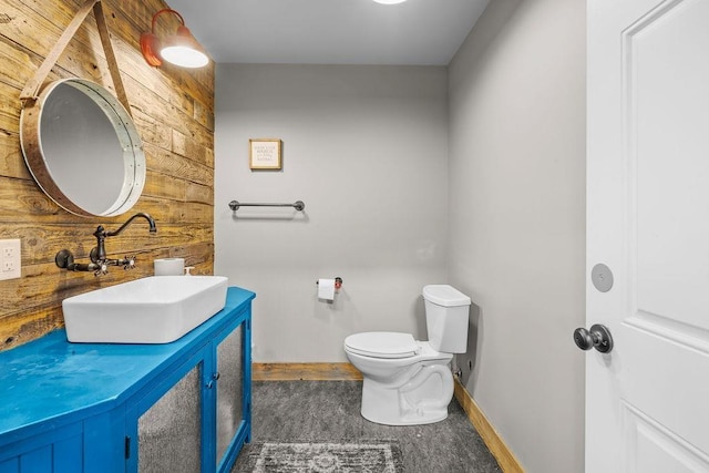 10409 E Grouse Mountain Ln, Spokane, WA 99206 - bathroom with wood walls, toilet, vanity, and baseboards
