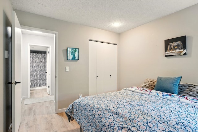 1002 W 7th Ave Unit 302, Spokane, WA 99204 - bedroom featuring light wood-style floors, a closet, a textured ceiling, and baseboards