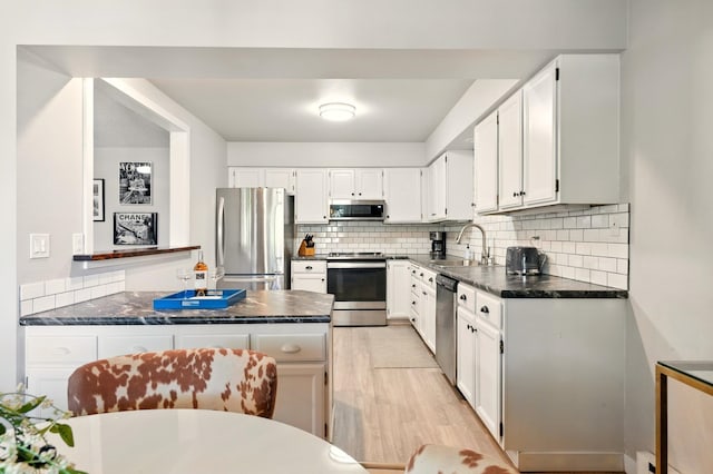 1002 W 7th Ave Unit 302, Spokane, WA 99204 - kitchen featuring stainless steel appliances, a sink, dark countertops, and decorative backsplash