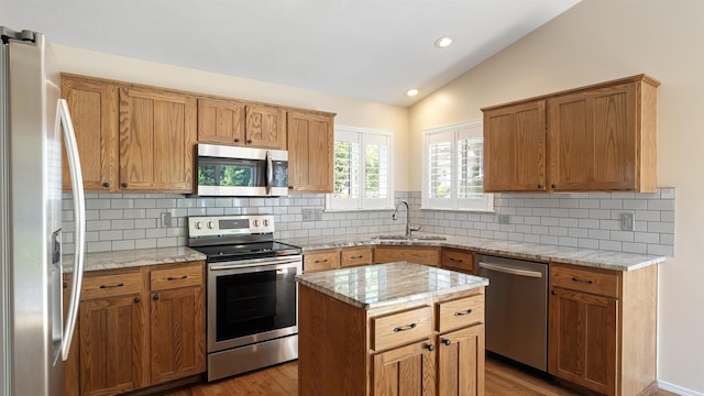 3404 W Excell Ave, Spokane, WA 99208 - kitchen with stainless steel appliances, a sink, lofted ceiling, decorative backsplash, and wood finished floors