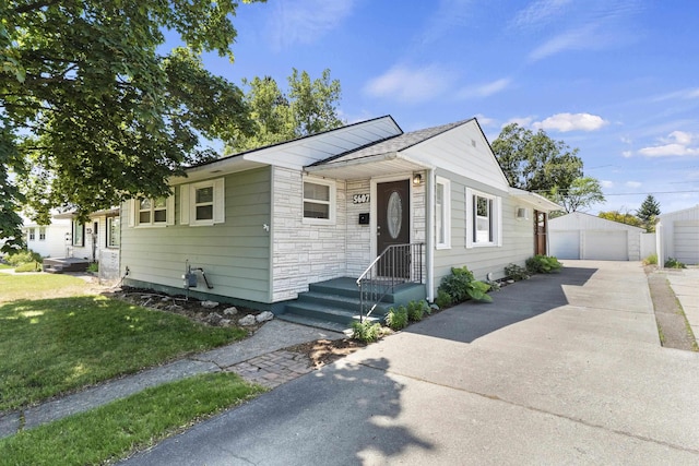5607 N Elgin St, Spokane, WA 99205 - view of front of home featuring a garage, an outdoor structure, stone siding, and a front lawn