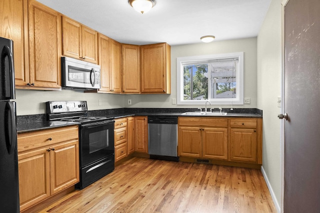 5607 N Elgin St, Spokane, WA 99205 - kitchen featuring black appliances, a sink, dark countertops, light wood finished floors, and brown cabinets