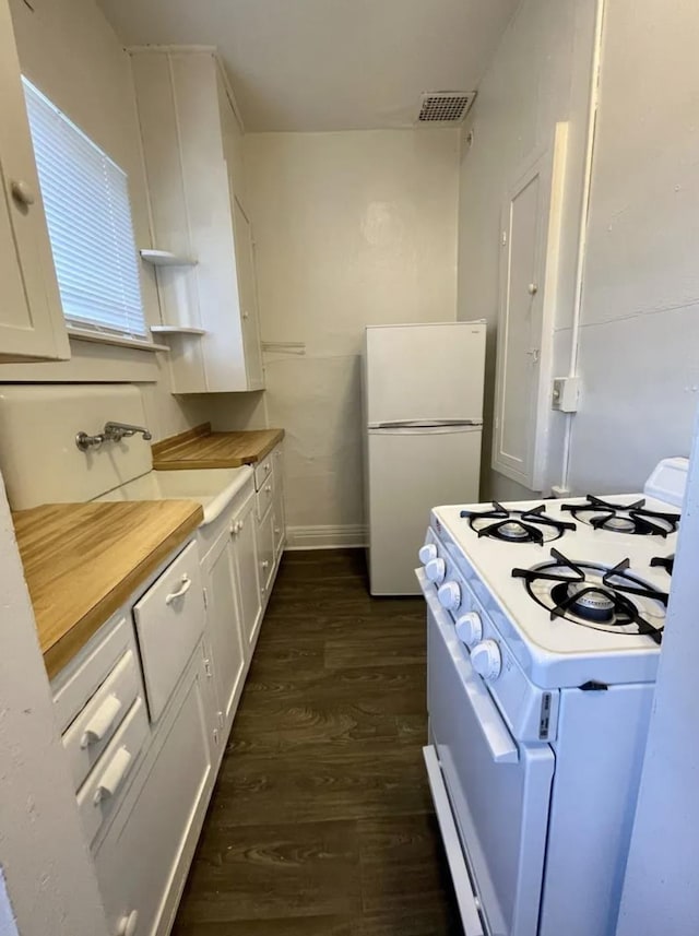 1101 W Maxwell Ave, Spokane, WA 99201 - kitchen with white appliances, dark wood-type flooring, white cabinets, open shelves, and baseboards