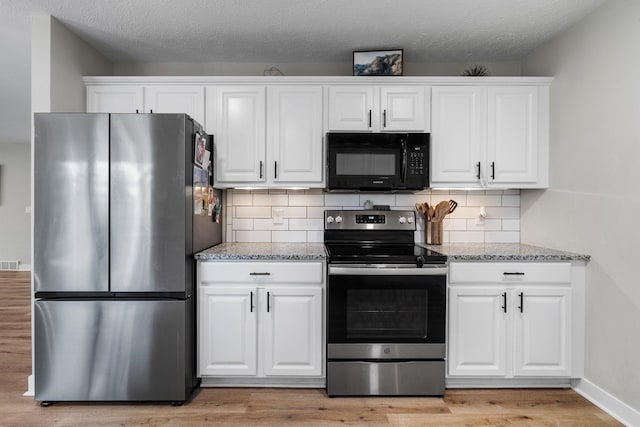 12327 E Sioux Cir, Spokane Valley, WA 99206 - kitchen with appliances with stainless steel finishes, light wood-type flooring, white cabinetry, and light stone counters