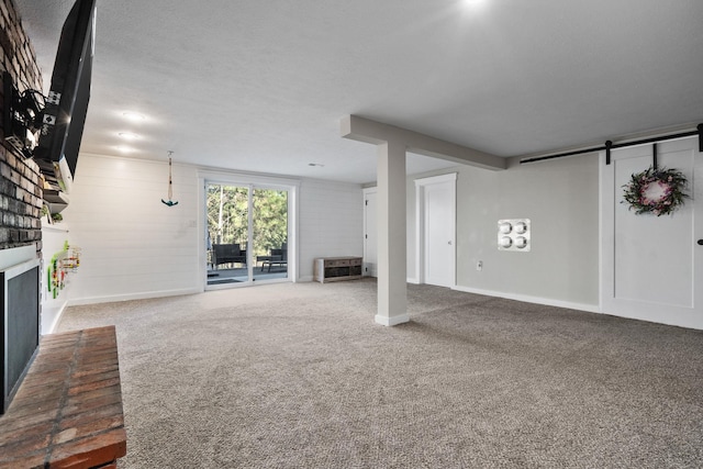 12327 E Sioux Cir, Spokane Valley, WA 99206 - unfurnished living room featuring a brick fireplace, carpet flooring, a barn door, and baseboards