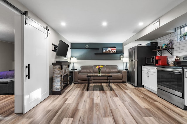 12327 E Sioux Cir, Spokane Valley, WA 99206 - living area with light wood-style floors, a barn door, a brick fireplace, and recessed lighting