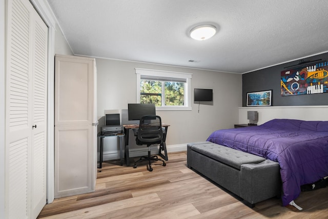 12327 E Sioux Cir, Spokane Valley, WA 99206 - bedroom with light wood-type flooring, a desk, and a textured ceiling