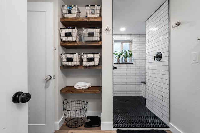 12327 E Sioux Cir, Spokane Valley, WA 99206 - bathroom with tiled shower, baseboards, and wood finished floors