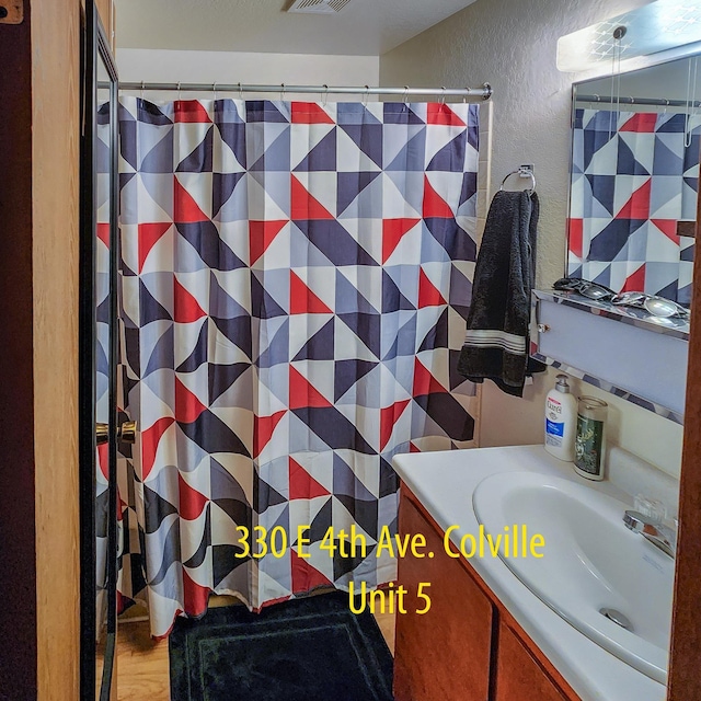330 E 4th Ave, Colville, WA 99114 - full bathroom with a textured wall, vanity, and a shower with shower curtain
