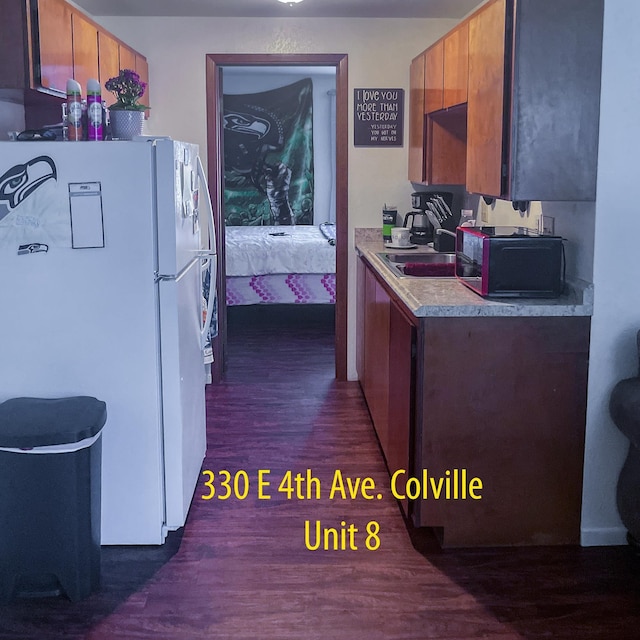 330 E 4th Ave, Colville, WA 99114 - kitchen with freestanding refrigerator, a sink, light countertops, dark wood-style floors, and brown cabinetry