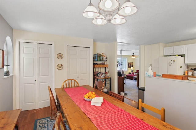 20201 E Lincoln Rd, Otis Orchards, WA 99027 - dining space featuring a chandelier, dark wood finished floors, a ceiling fan, and arched walkways