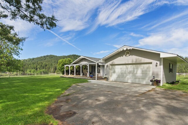 20201 E Lincoln Rd, Otis Orchards, WA 99027 - view of front of house with covered porch, asphalt driveway, a garage, and a forest view