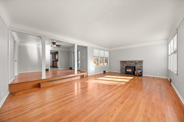 2828 S Arthur St, Spokane, WA 99203 - unfurnished living room featuring ornate columns, plenty of natural light, light wood finished floors, and a fireplace