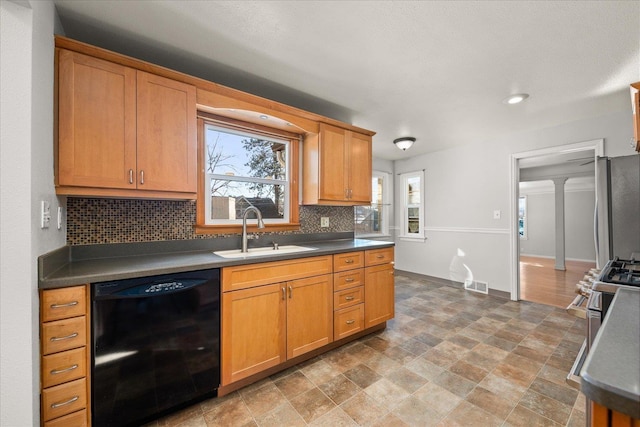 2828 S Arthur St, Spokane, WA 99203 - kitchen with appliances with stainless steel finishes, a sink, backsplash, stone finish flooring, and dark countertops