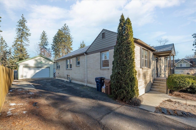 2828 S Arthur St, Spokane, WA 99203 - view of side of home featuring a detached garage, brick siding, and an outbuilding