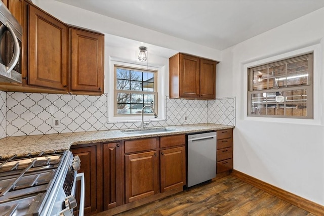 10503 E Valleyway Ave, Spokane Valley, WA 99206 - kitchen with a sink, stainless steel appliances, light stone countertops, dark wood-type flooring, and brown cabinets