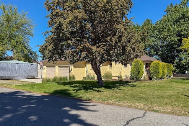 10503 E Valleyway Ave, Spokane Valley, WA 99206 - view of property hidden behind natural elements with a garage, stucco siding, a front yard, and driveway