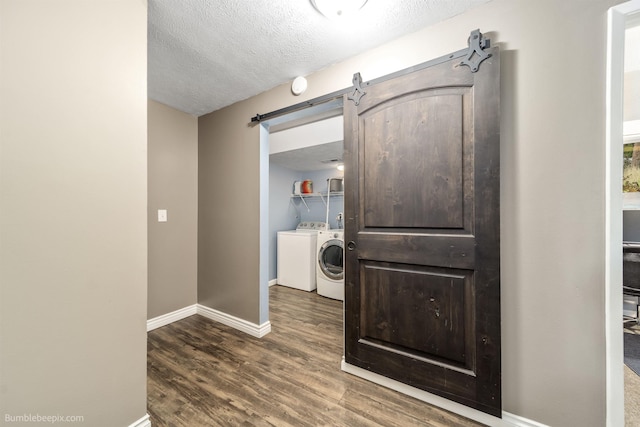 4116 W Indian Trail Rd, Spokane, WA 99208 - washroom with baseboards, dark wood finished floors, washing machine and dryer, a textured ceiling, and a barn door