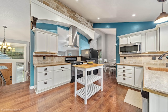 4116 W Indian Trail Rd, Spokane, WA 99208 - kitchen with stainless steel microwave, gas range, exhaust hood, a sink, and freestanding refrigerator