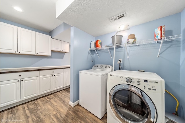 4116 W Indian Trail Rd, Spokane, WA 99208 - washroom with washing machine and dryer, wood finished floors, cabinet space, a textured ceiling, and baseboards