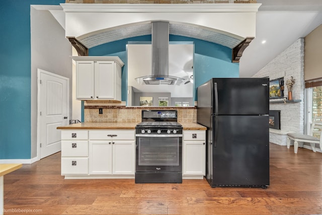 4116 W Indian Trail Rd, Spokane, WA 99208 - kitchen featuring freestanding refrigerator, range with gas stovetop, island exhaust hood, white cabinetry, and light wood-style flooring