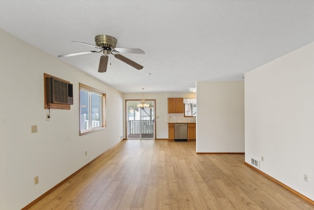 11103 E Main Ave, Spokane Valley, WA 99206 - unfurnished living room featuring a chandelier, a wall mounted AC, light wood-style floors, ceiling fan, and baseboards