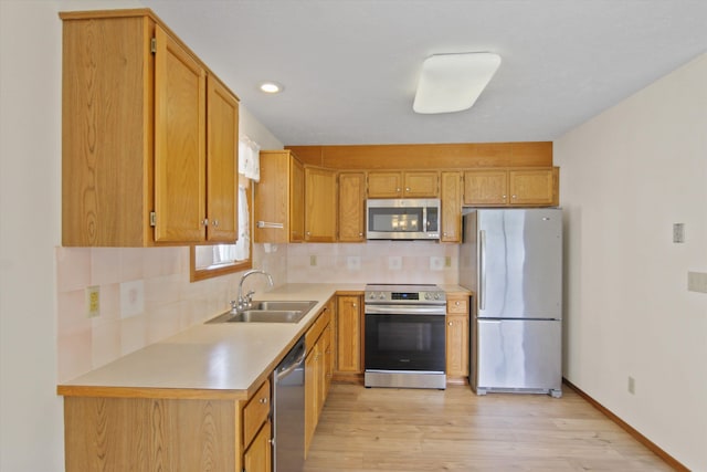 11103 E Main Ave, Spokane Valley, WA 99206 - kitchen featuring appliances with stainless steel finishes, tasteful backsplash, light countertops, light wood-style floors, and a sink