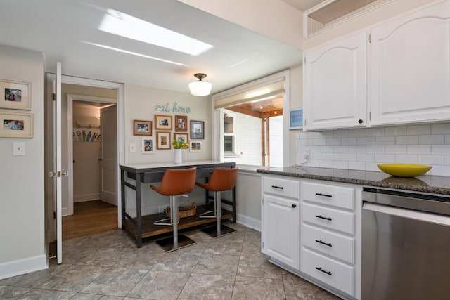 704 E 20th Ave, Spokane, WA 99203 - kitchen with dishwasher, baseboards, white cabinetry, tasteful backsplash, and dark stone counters