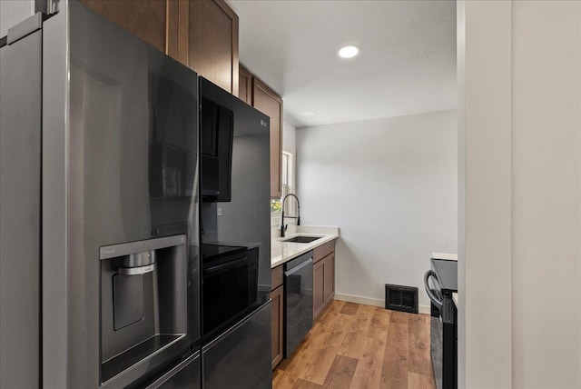 1403 N Farr Rd, Spokane, WA 99206 - kitchen with fridge with ice dispenser, a sink, dishwasher, light wood-style flooring, and black range