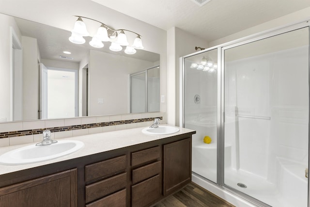 822 S Oswald St, Spokane, WA 99224 - full bathroom with a shower stall, backsplash, double vanity, and wood finished floors