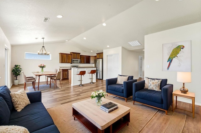 822 S Oswald St, Spokane, WA 99224 - living area with light wood-style floors, lofted ceiling, baseboards, recessed lighting, and a chandelier