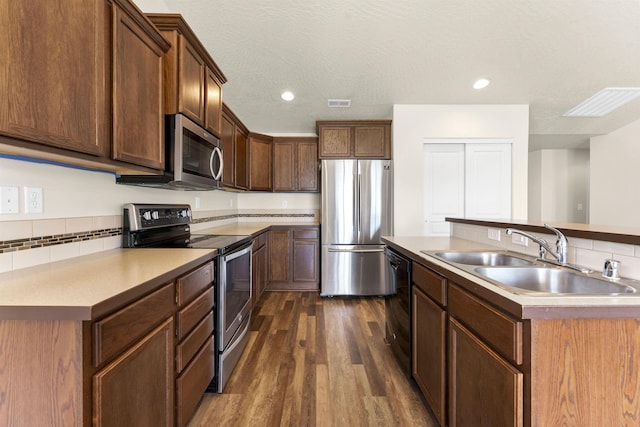 822 S Oswald St, Spokane, WA 99224 - kitchen with stainless steel appliances, a sink, dark wood-style floors, decorative backsplash, and light countertops
