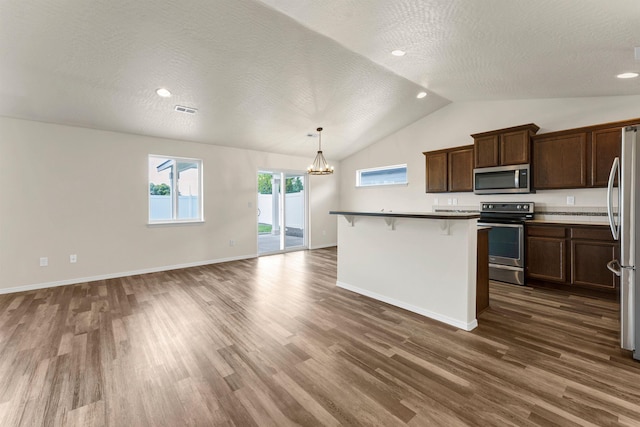 822 S Oswald St, Spokane, WA 99224 - kitchen featuring appliances with stainless steel finishes, a chandelier, vaulted ceiling, a breakfast bar, and dark wood finished floors