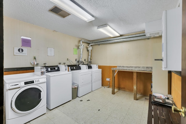 28600 N Mt Spokane Park Dr Unit 603, Mead, WA 99021 - communal laundry room with washer and dryer, light flooring, a textured ceiling, and wood walls