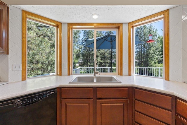 4510 E Bixel Ct, Mead, WA 99021 - kitchen featuring a sink, dishwasher, light countertops, a textured ceiling, and brown cabinetry