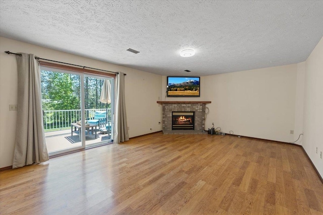 4510 E Bixel Ct, Mead, WA 99021 - unfurnished living room with light wood-style floors, a fireplace, baseboards, and a textured ceiling