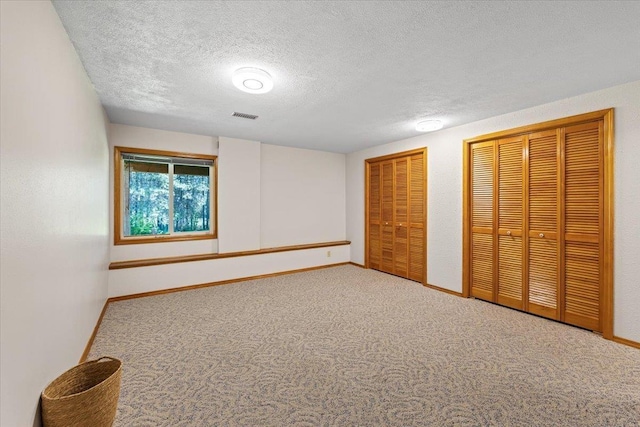 4510 E Bixel Ct, Mead, WA 99021 - unfurnished bedroom with two closets, carpet, baseboards, and a textured ceiling