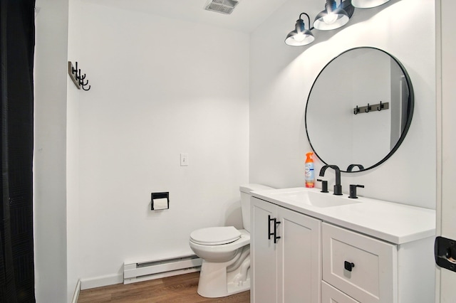 14018 E Valleyway Ave, Spokane, WA 99216 - bathroom featuring baseboard heating, wood finished floors, toilet, vanity, and baseboards