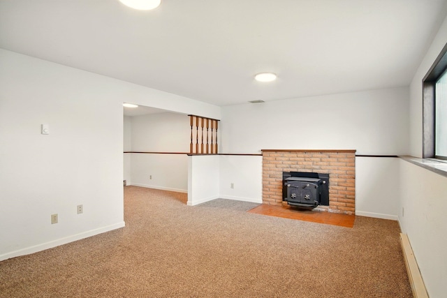 14018 E Valleyway Ave, Spokane, WA 99216 - unfurnished living room featuring carpet flooring, a wood stove, and baseboards