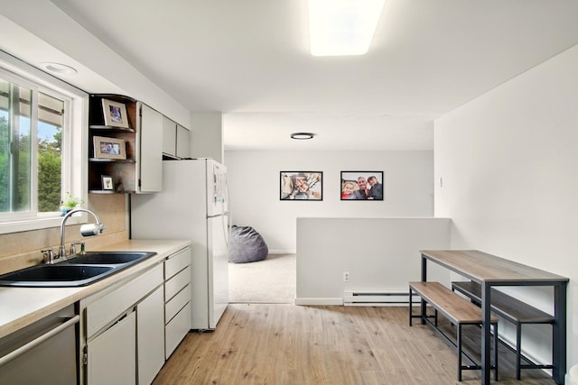 14018 E Valleyway Ave, Spokane, WA 99216 - kitchen featuring stainless steel dishwasher, light countertops, light wood-style flooring, a baseboard radiator, and tasteful backsplash