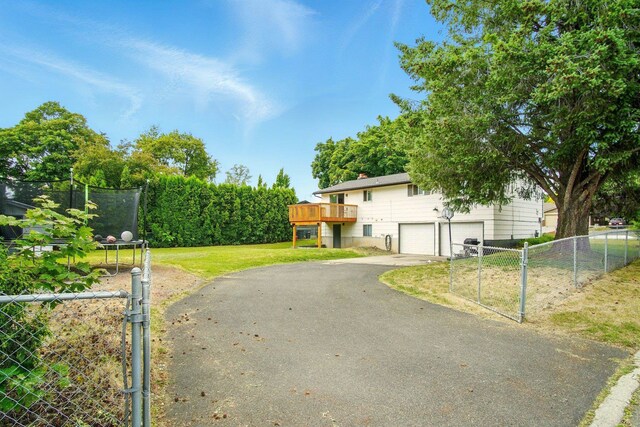 14018 E Valleyway Ave, Spokane, WA 99216 - view of front of house with asphalt driveway, a garage, a gate, a wooden deck, and a chimney