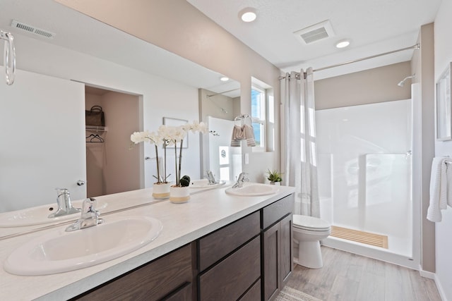 713 E L St, Deer Park, WA 99006 - full bath featuring a shower with shower curtain, double vanity, toilet, and wood finished floors