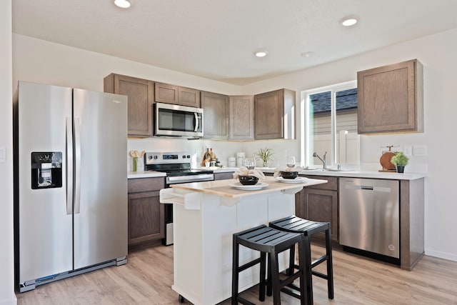 713 E L St, Deer Park, WA 99006 - kitchen featuring stainless steel appliances, light wood-style flooring, light countertops, a breakfast bar, and recessed lighting