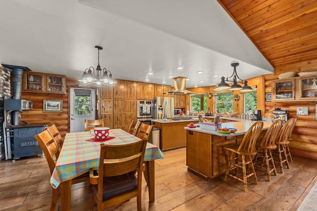 312 Pickett Rd, Ione, WA 99139 - dining space featuring a chandelier, light wood-style flooring, recessed lighting, rustic walls, and a wood stove
