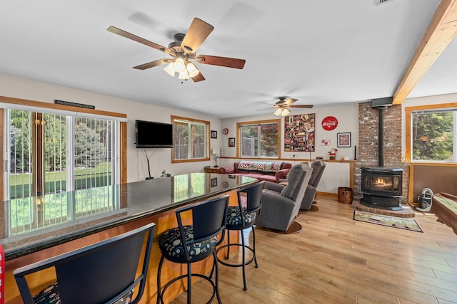 312 Pickett Rd, Ione, WA 99139 - kitchen featuring a wood stove, light wood-style flooring, a ceiling fan, and open floor plan