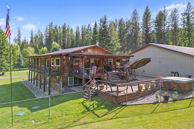 312 Pickett Rd, Ione, WA 99139 - rear view of house featuring log siding, a hot tub, a deck, and a wooded view